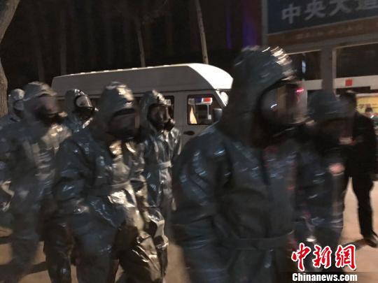 十几名身着防护服的人员头戴面具进入事发地。　胡健 摄